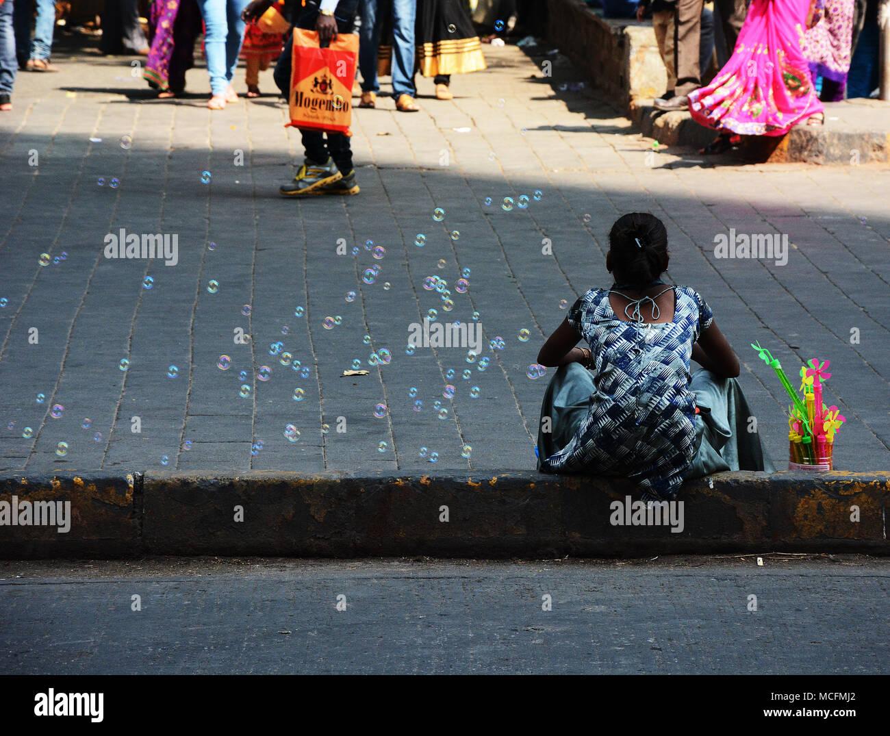 Frau saß auf einer Kandare, Verkauf von Spielzeug und Seifenblasen in Mumbai, Indien Stockfoto