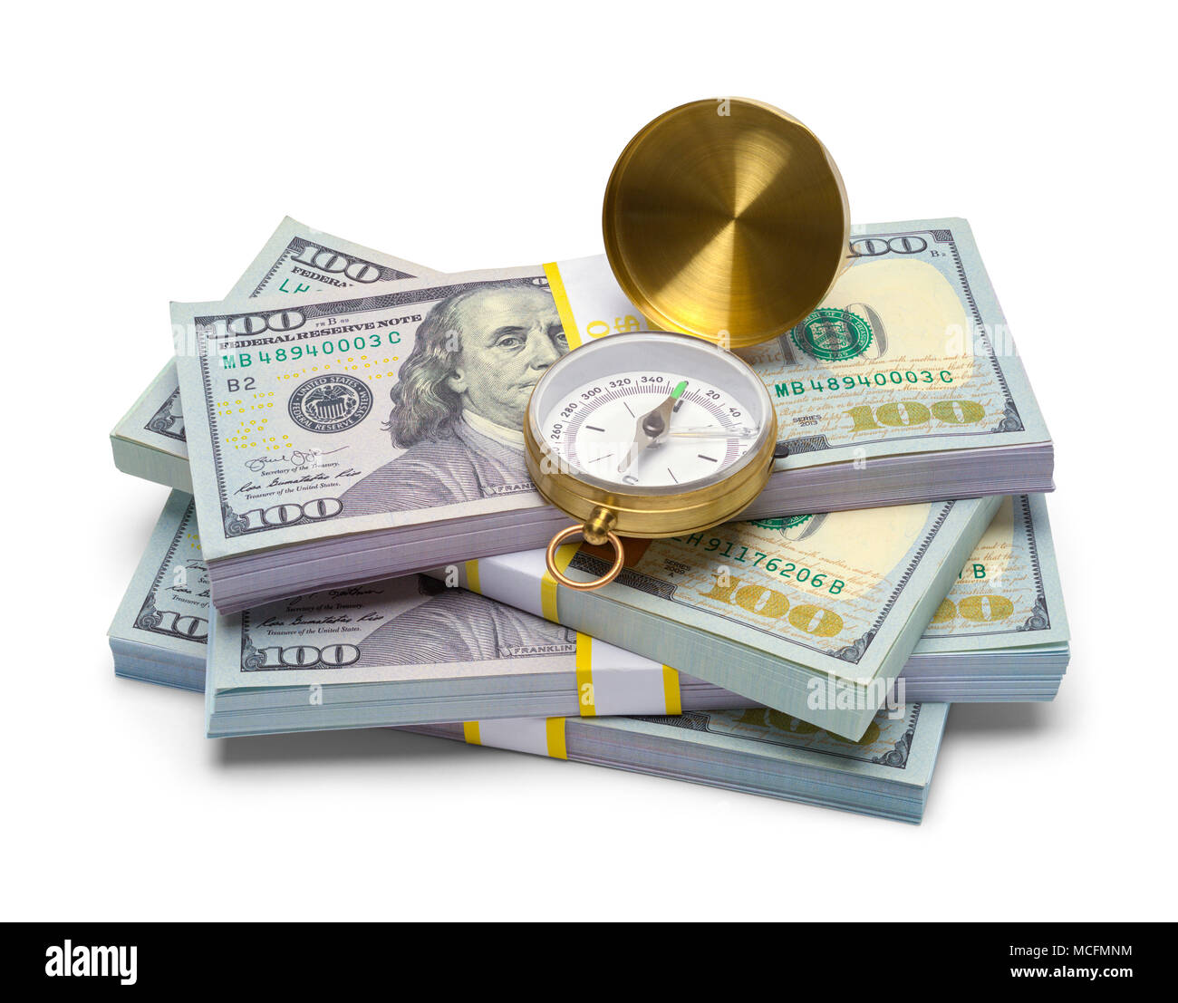 Haufen Geld mit einem offenen Kompass isoliert auf einem weißen Hintergrund. Stockfoto
