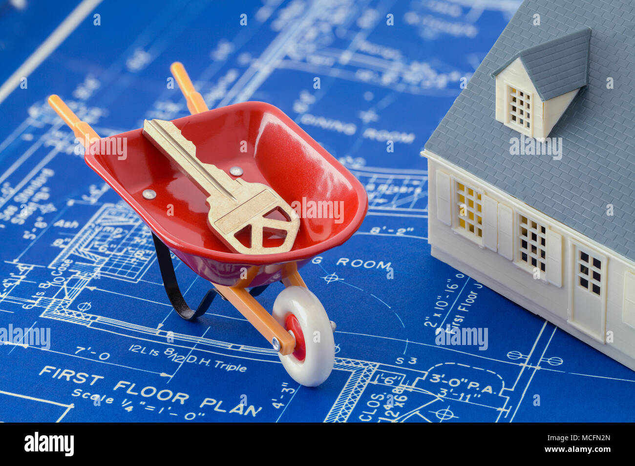 Blueprints mit einem Modell Haus und Wheel Barrow mit Schlüssel. Stockfoto