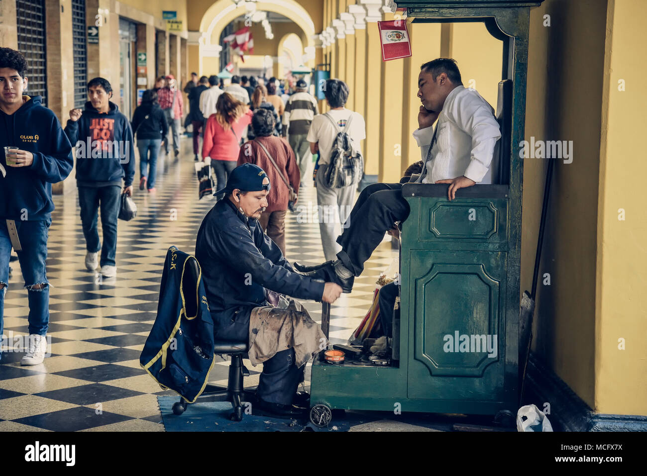 Lima/Peru - 07.18.2017: Kolumne Mann bei der Arbeit auf der Straße Polieren der Schuhe. Stockfoto