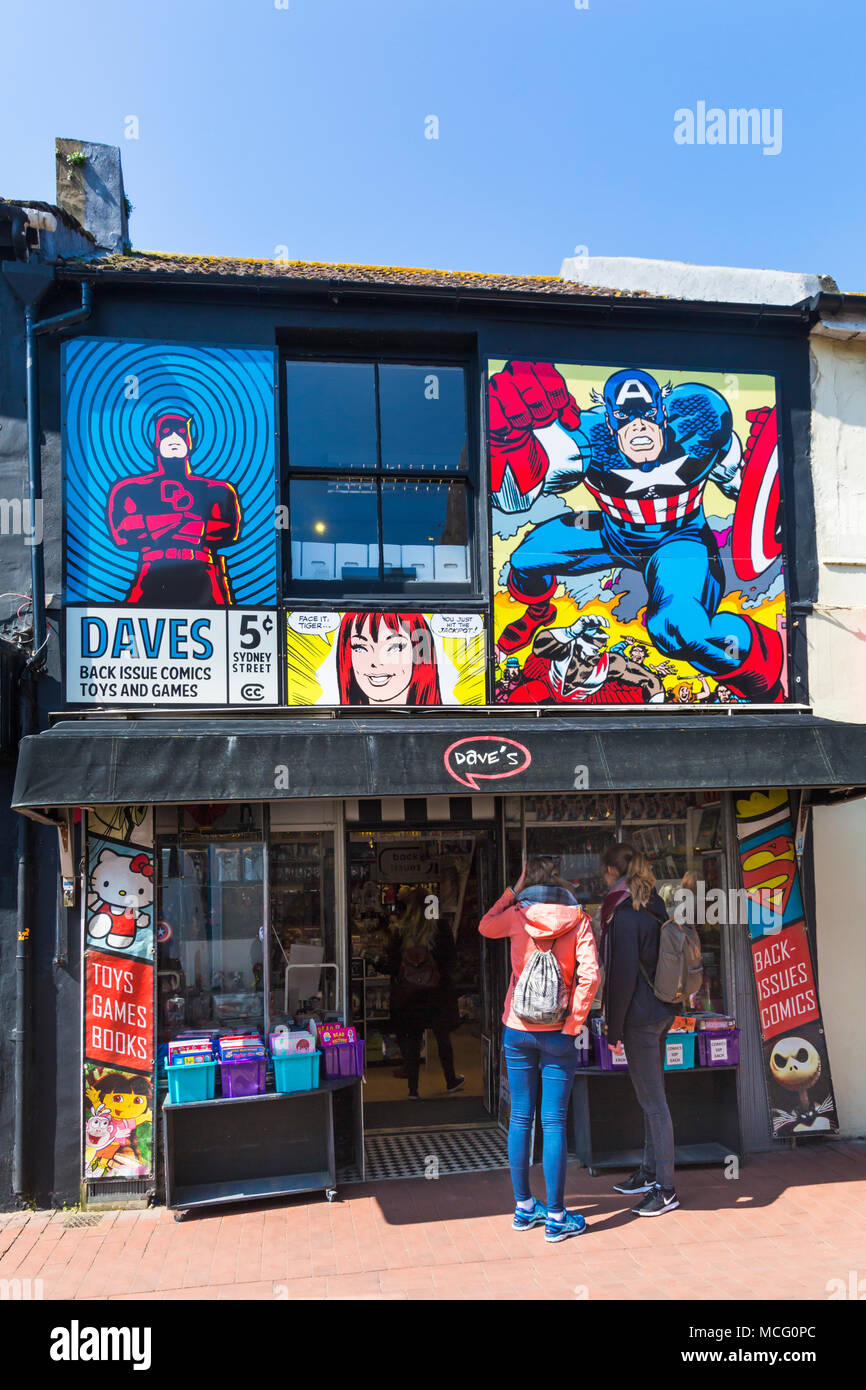 Zwei junge Frauen in Dave's Comics Brighton Buchhandlung an Sydney Street, Brighton, East Sussex, England UK suchen im April Stockfoto