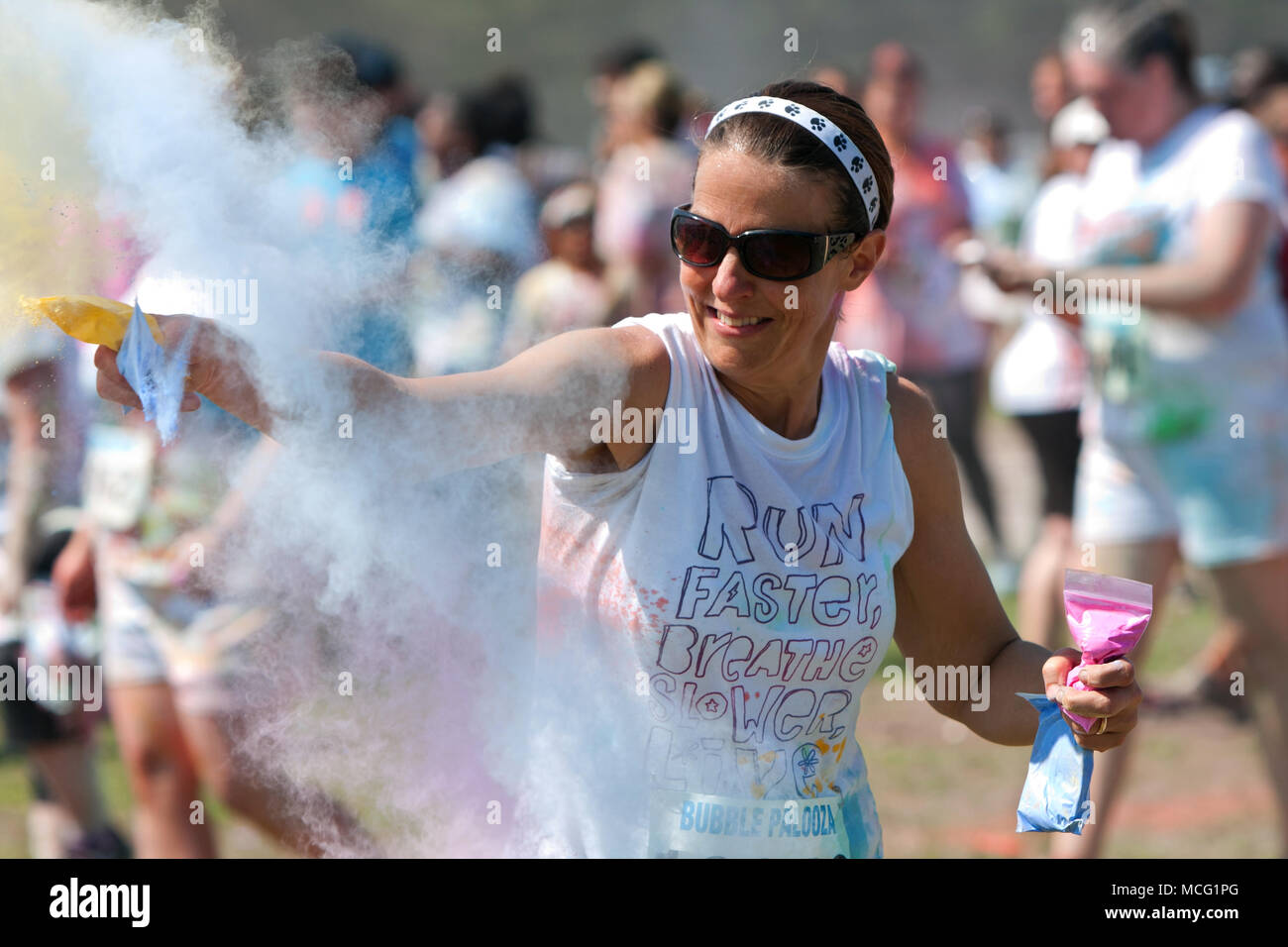 Lawrenceville, GA, USA - 31. Mai 2014: Eine Frau wirft Pakete von farbigen Maisstärke auf andere an der Bubble Palooza. Stockfoto