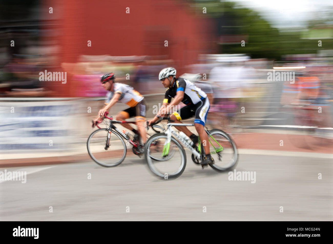 Duluth, GA, Vereinigte Staaten - 2 August 2014: Bunte Bewegungsunschärfe von zwei Radfahrer Beschleunigung von, wie sie beim Rennen in der Georgia Schale, ein Kriterium Fall konkurrieren. Stockfoto