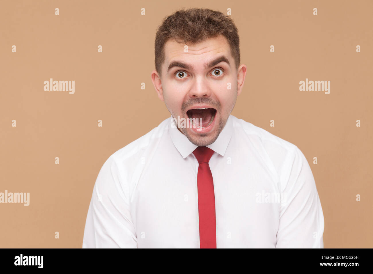Closeup Portrait von schockiert Mann offenen Mund. Business Personen Konzept, gute und schlechte Emotionen und Gefühle. Studio shot, auf Hellbraunem backgroun isoliert Stockfoto