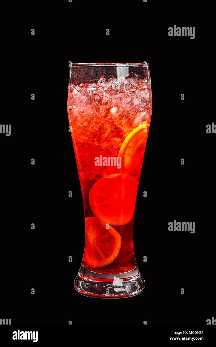 Single - Farbe transparent Cocktail, Orange, Rot erfrischende in ein hohes Glas mit crushed Ice frappe und runde Scheiben von Orange, Zitrone. Von der Seite. Isolat Stockfoto Single - Farbe transparent Cocktail, Orange, Rot erfrischende in ein hohes Glas mit crushed Ice frappe und runde Scheiben von Orange, Zitrone. Von der Seite. Isolat Stockfoto