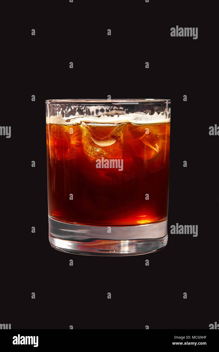 1-farbigen, transparenten Cocktail, Braun, Rot erfrischende mit Schaumstoff in ein Glas mit Eiswürfeln und Cola Geschmack mit Kohlensäure. Von der Seite. Isolierte blac Stockfoto