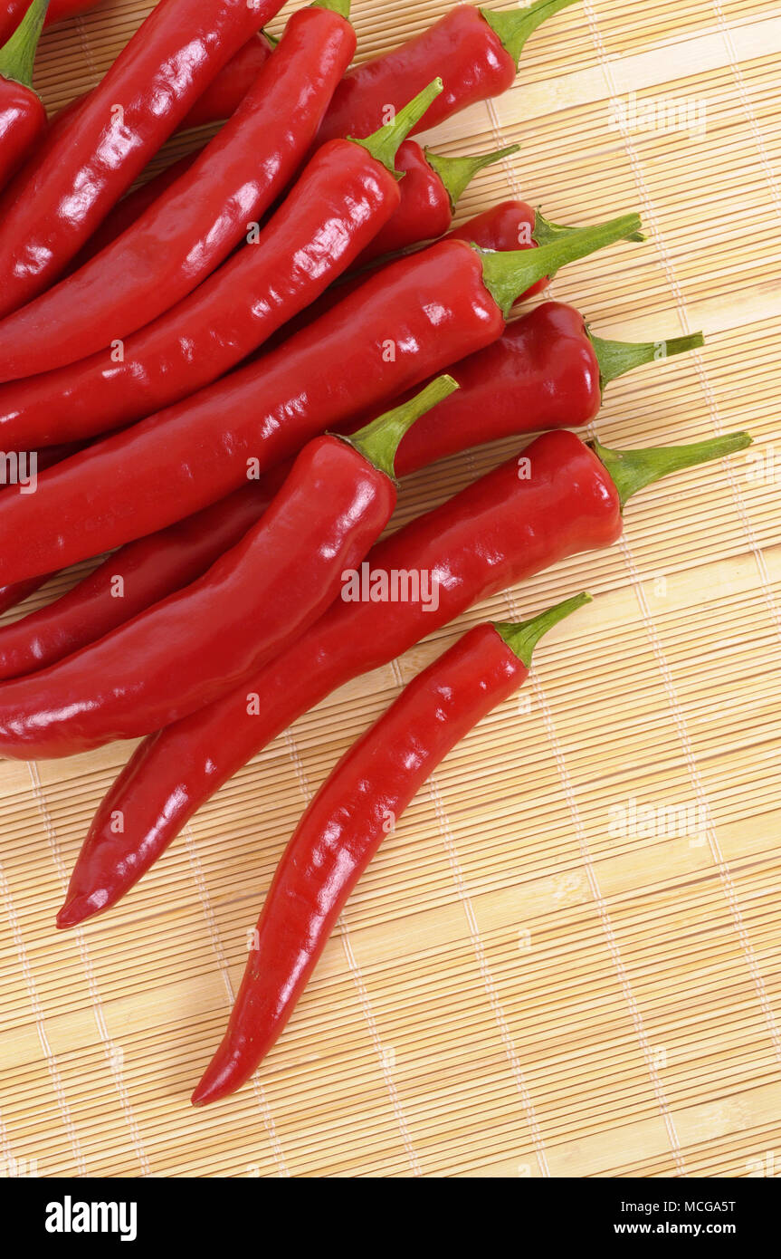 Stapel von red chili peppers auf einem Bambus Küche mat Stockfoto