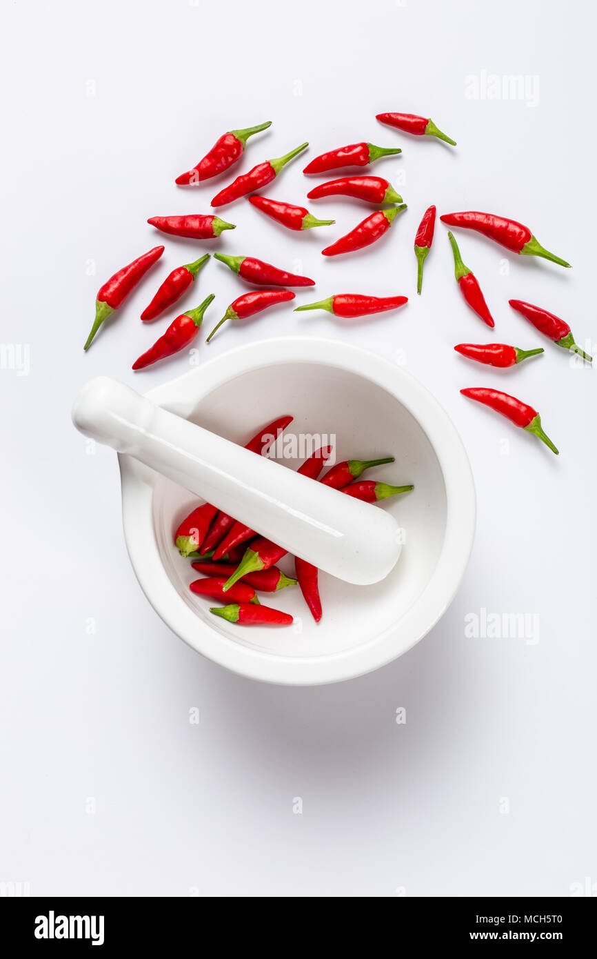 Weiß Mörser und Stößel mit roten Chilis im Hochformat mit Raum für Text Stockfoto