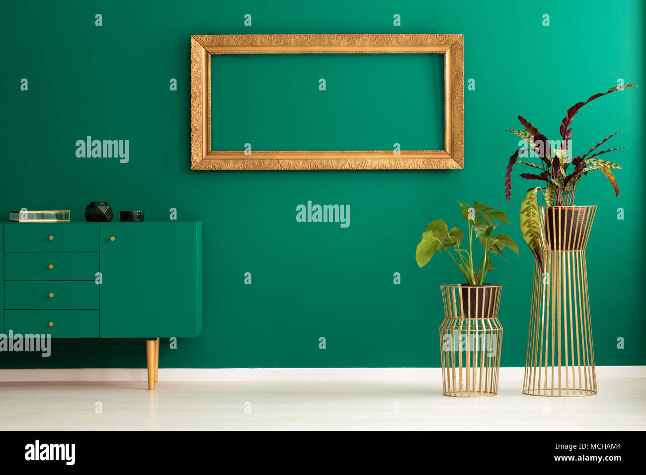 Pflanzen und grün Schrank im Vorraum Interieur mit leeren gold Rahmen auf der Wand Stockfoto