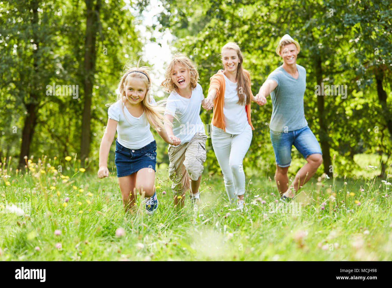Glückliche Familie und Kinder haben Spaß im Garten im Sommer Stockfoto