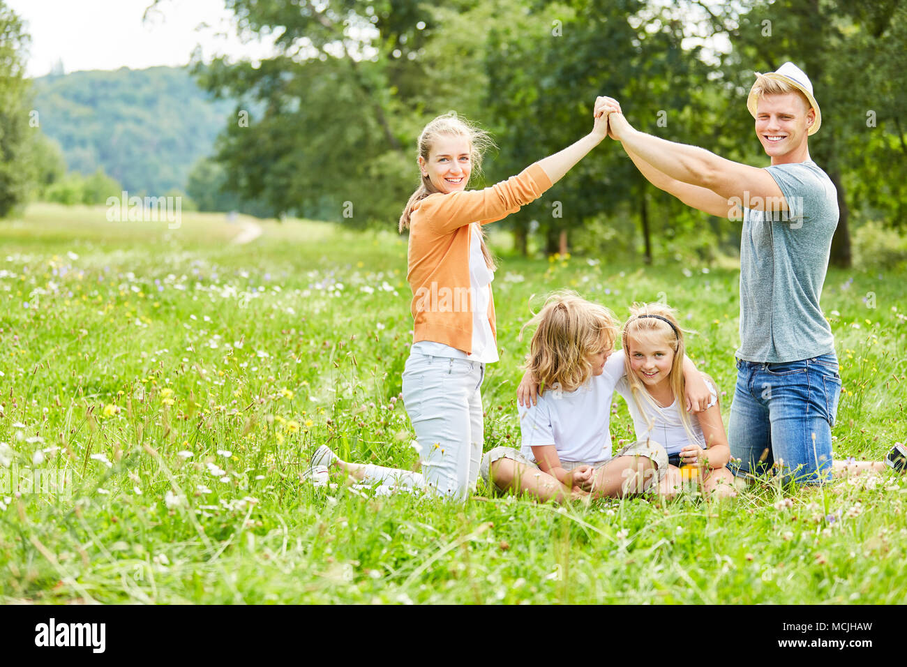 Glückliche Familie und Kinder freuen sich auf ein Haus in der Zukunft Stockfoto