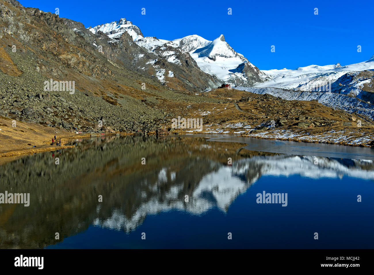 See Stellisee mit Blick auf das Bergrestaurant Fluhalp und Gipfeln Adlerhorn und Zermatt, Wallis, Schweiz Stockfoto