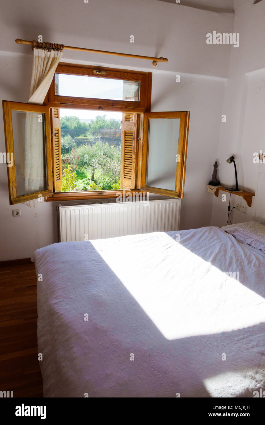 Blick auf ein Schlafzimmer mit geöffneten Fenstern, Griechenland Stockfoto
