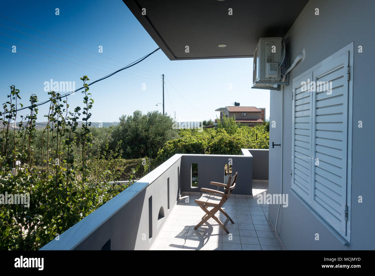 Leerer Stuhl, Balkon mit Blick auf tree Plantation Stockfoto