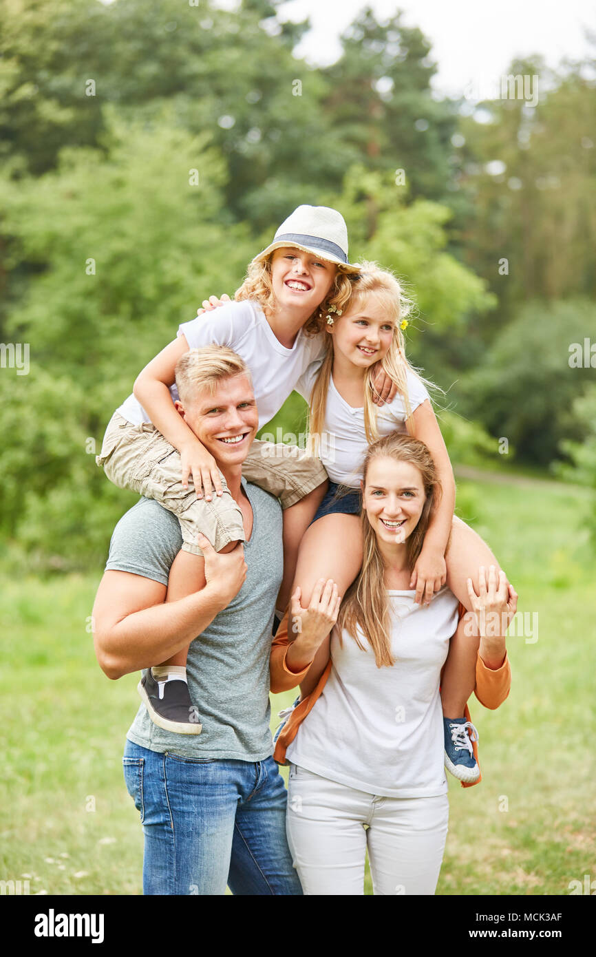 Eltern piggyback ihren zwei Kindern und Freude Stockfoto