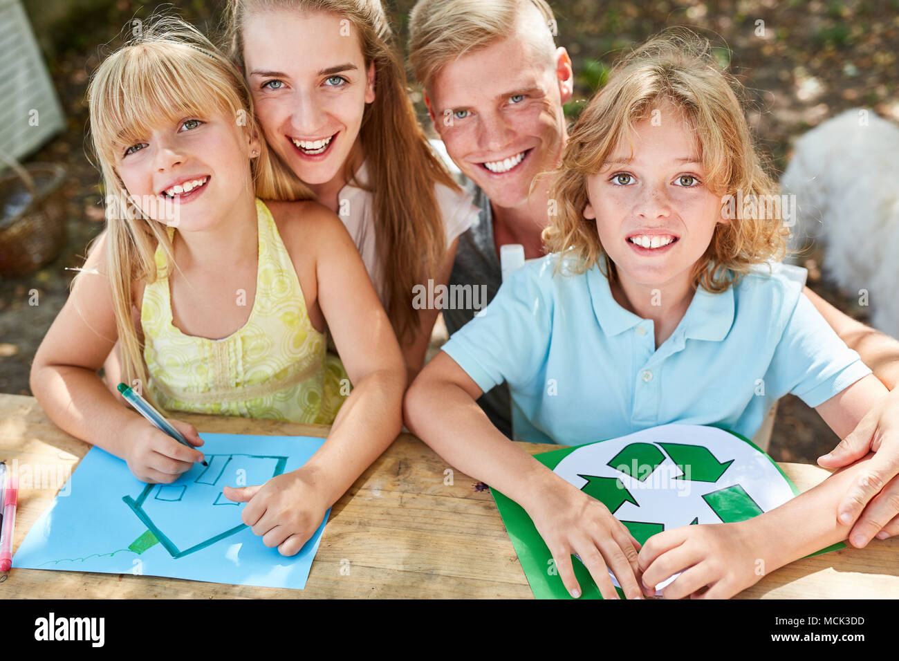 Glückliche Familie und Kinder malen eco Recycling Logo und Home Stockfoto