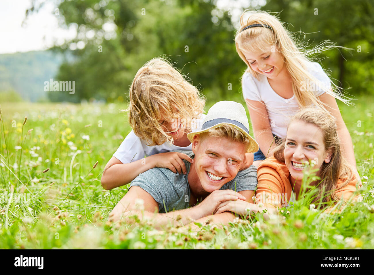 Kinder haben Spaß beim Spielen mit ihren Eltern auf einer Sommerwiese Stockfoto