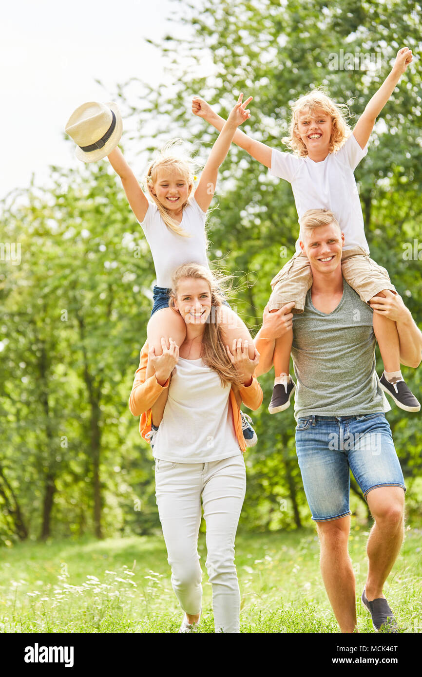 Eltern mit glücklichen Kindern Huckepack auf einer Reise im Sommer Stockfoto
