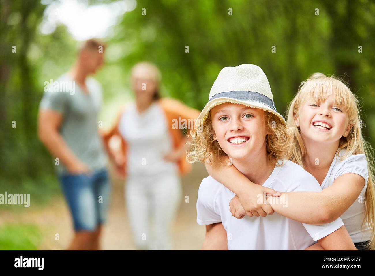 Glückliche Kinder auf eine Urlaubsreise mit Eltern im Hintergrund Stockfoto