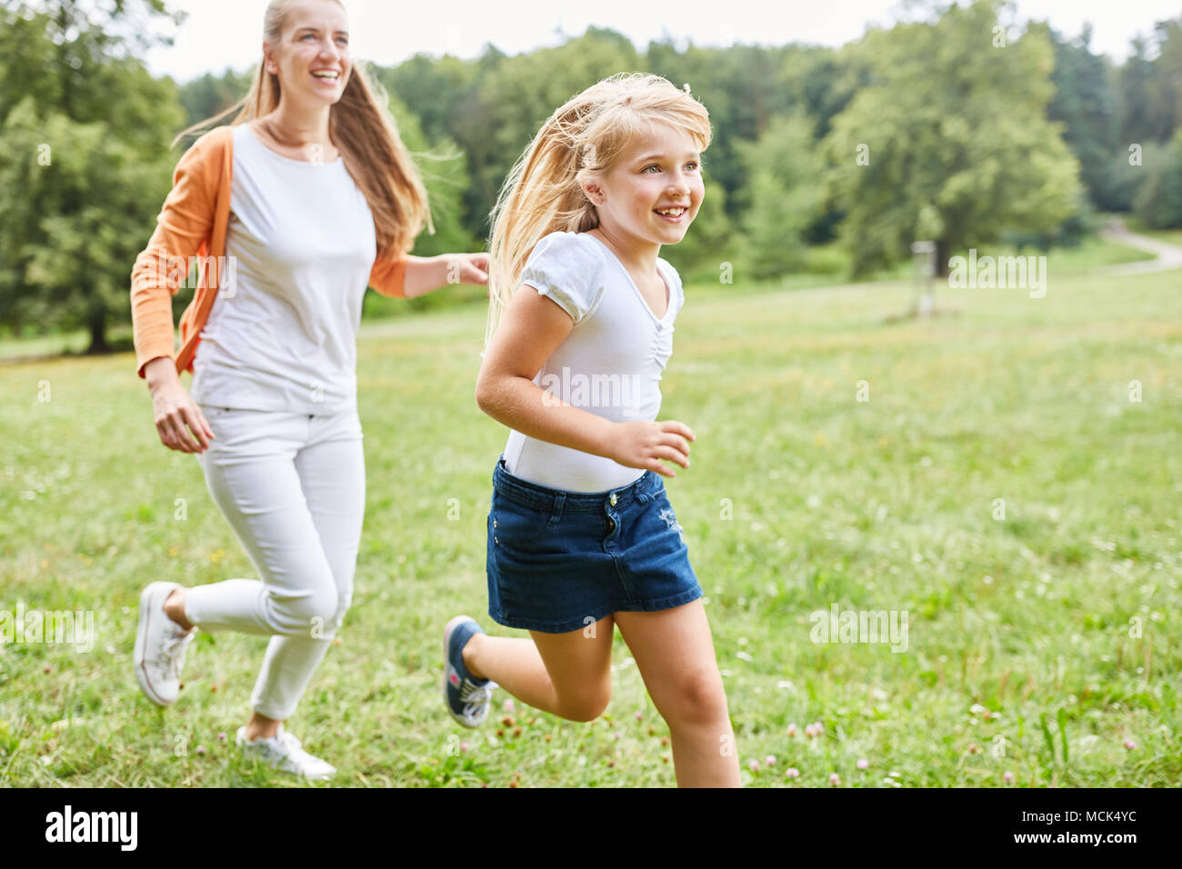 Mutter und Tochter machen ein Rennen auf einer Wiese im Sommer Stockfoto