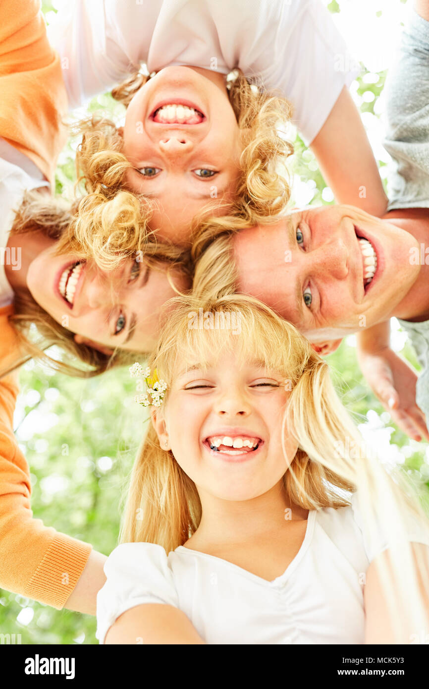Blonde Mädchen und ihre Familie bilden einen Kreis und lachen glücklich Stockfoto