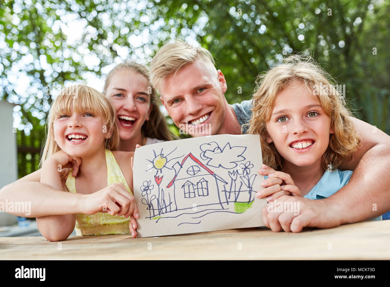 Glückliche Familie und Kinder mit Zeichnung von Dream House Stockfoto