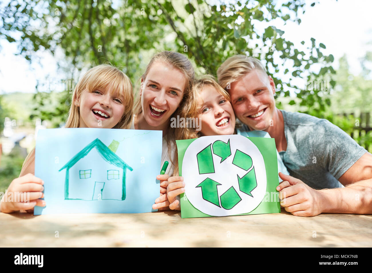 Glückliche Familie mit Zeichnung von Dream House und Recycling Logo Stockfoto