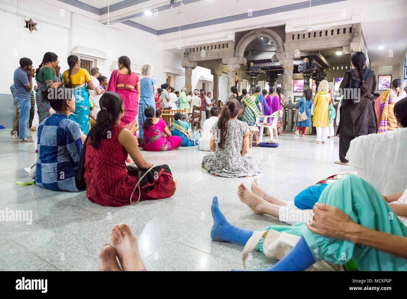 Ashram von Sri Ramana Maharshi, Tiruvannamalai, Tamil Nadu, Indien - März circa, 2018. Nicht identifizierte Frau und Mann sitzen auf dem Boden des Ashram Stockfoto