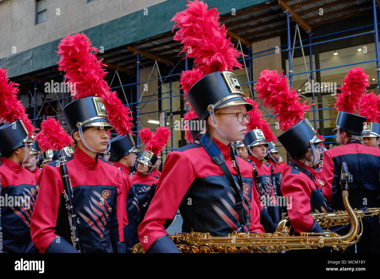 Johns Creek High School Band in New York St. Patrick's Day Parade, 2018. Rote und Dunkle Blaue Uniformen, rote Feder Federn. Saxophone, Klarinette. Stockfoto