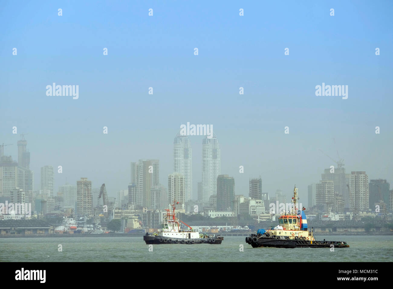 Ansicht der Schlepper in Back Bay aus Norman Punkt mit den Wolkenkratzern von Colaba und moderne Mumbai im Hintergrund. Hafen von Mumbai Stockfoto