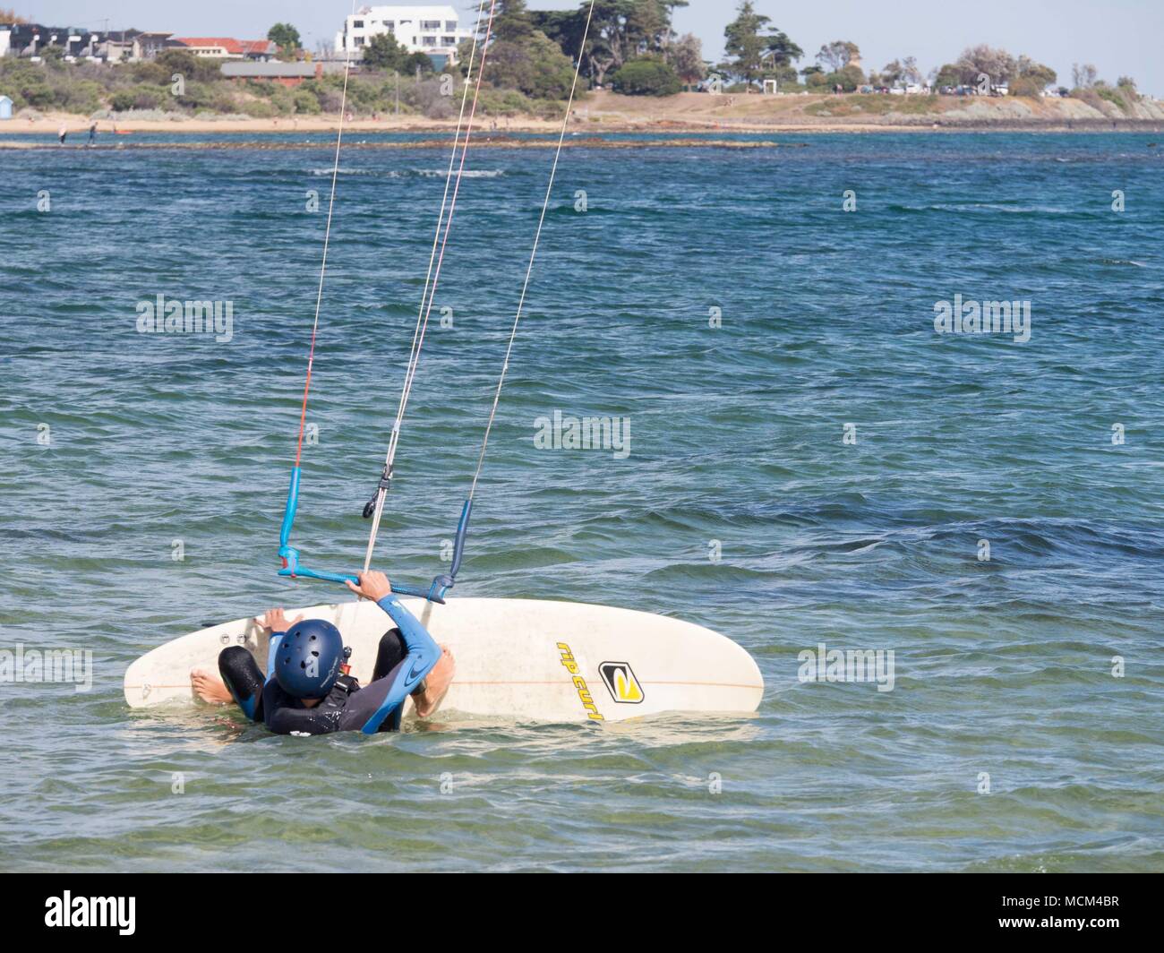 Kitesurfer und Kitesurfer auf Port Phillip Bay Australien über Wasser, Tricks, fliegen in der Luft an einem warmen sonnigen blauen Himmel Tag Stockfoto