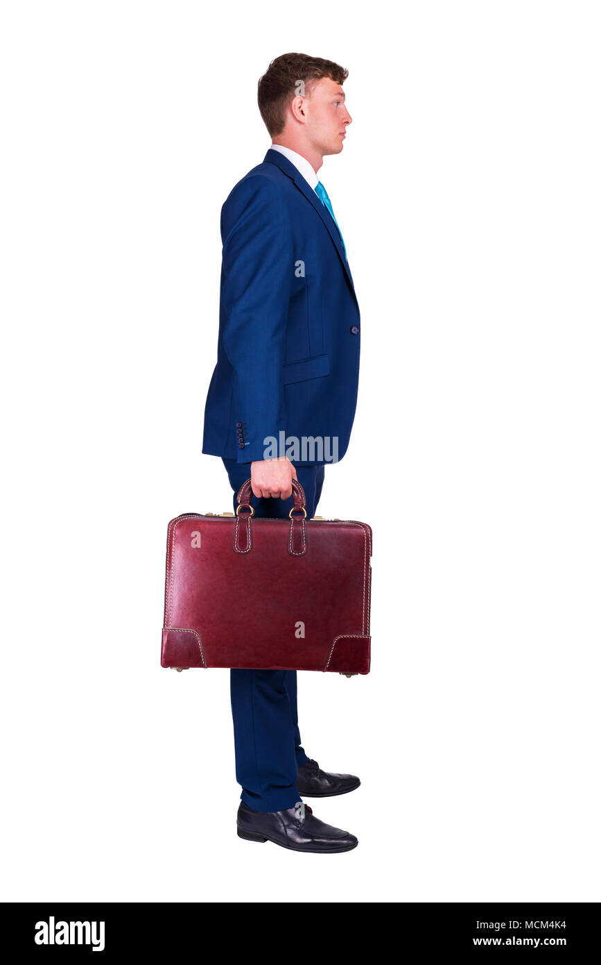 Unternehmer im feinen Anzug mit einer Hand Koffer, stehend auf dem isolierten Hintergrund. Stockfoto