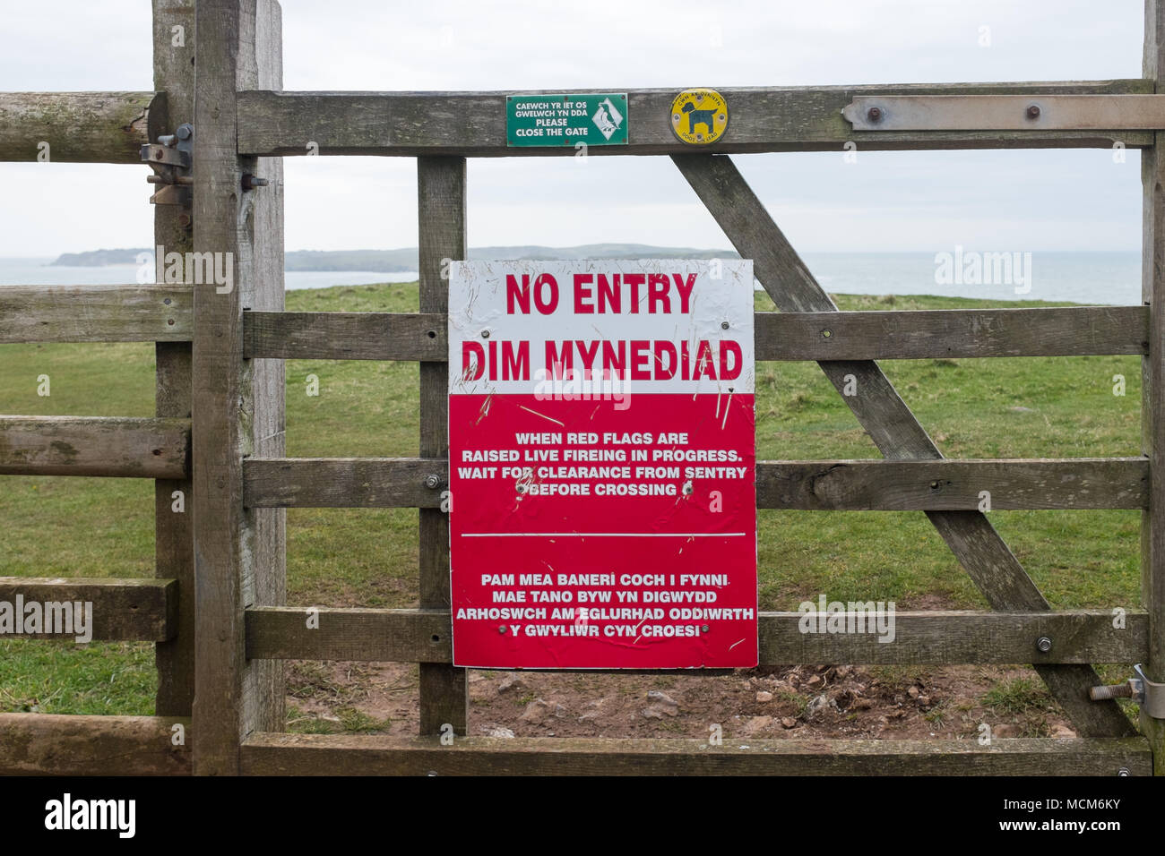 Bundesministerium der Verteidigung auf hölzerne Tor am Eingang der schießplatz an Penally, Pembrokeshire, Wales, nein zu sagen, wenn rote Fahnen Fliegen Stockfoto