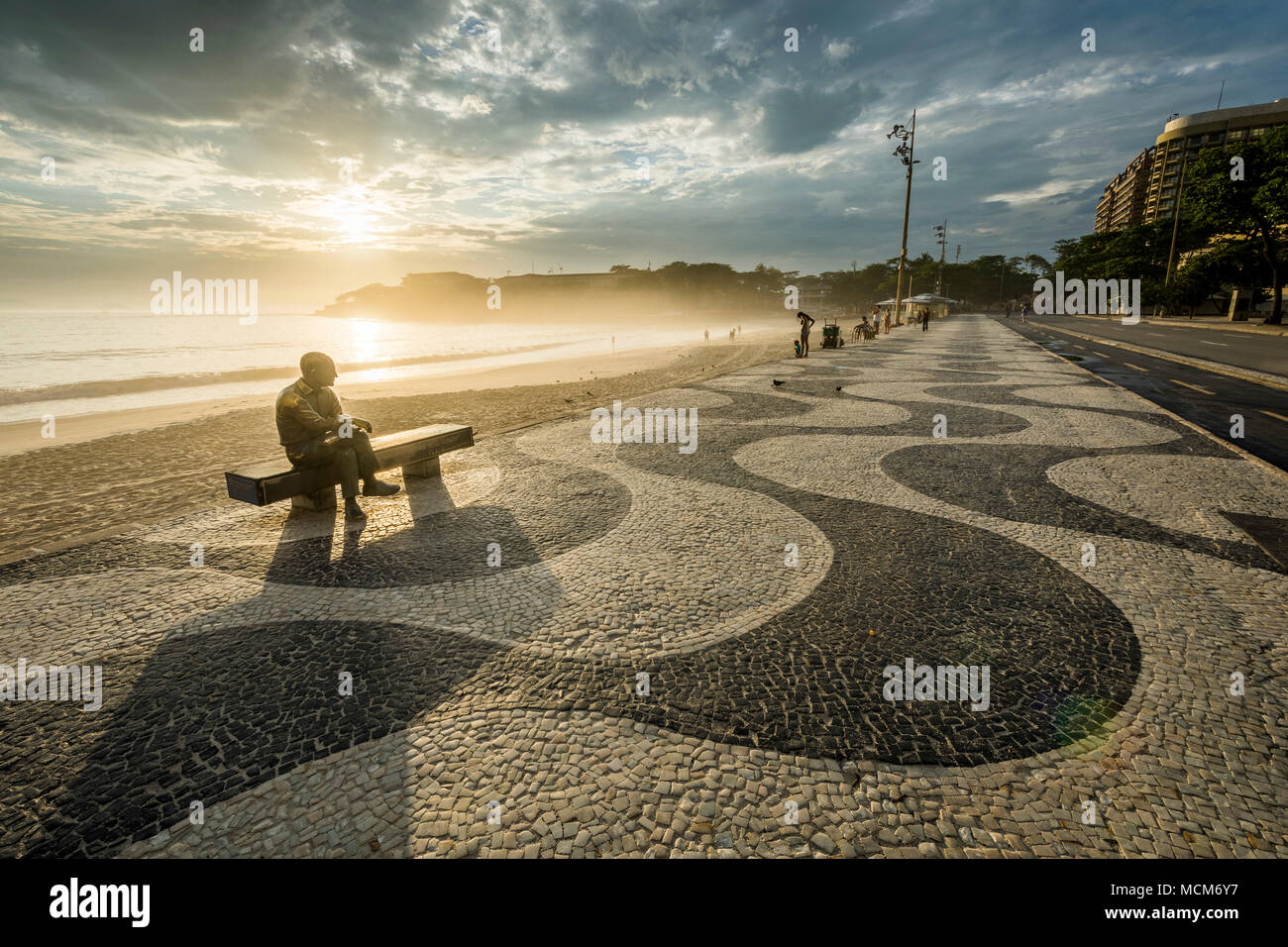 Statue von Carlos Drummond de Andrade (Brasilianische Dichter) bei Sonnenaufgang in Copacabana, Rio de Janeiro, Brasilien gesehen Stockfoto