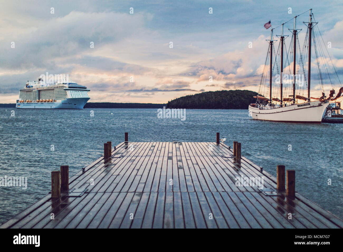 Ein Kreuzfahrtschiff tropfen Anker in der Nähe von einem alten Segelschiff in Bar Harbor, Maine, in der Nähe von Acadia National Park im Sommer Hochsaison. Stockfoto