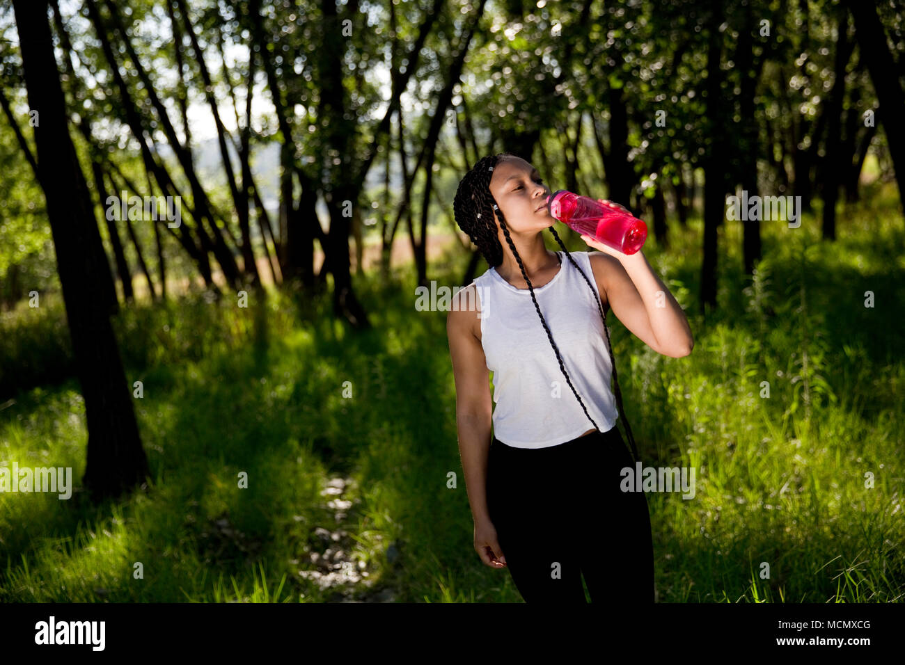Frau trinkt Wasser in einem Park Stockfoto