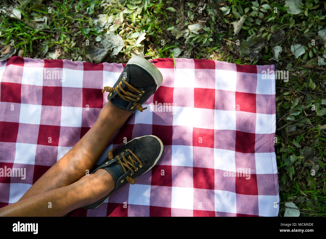 Gekreuzten Beinen auf einer Picknickdecke Stockfoto