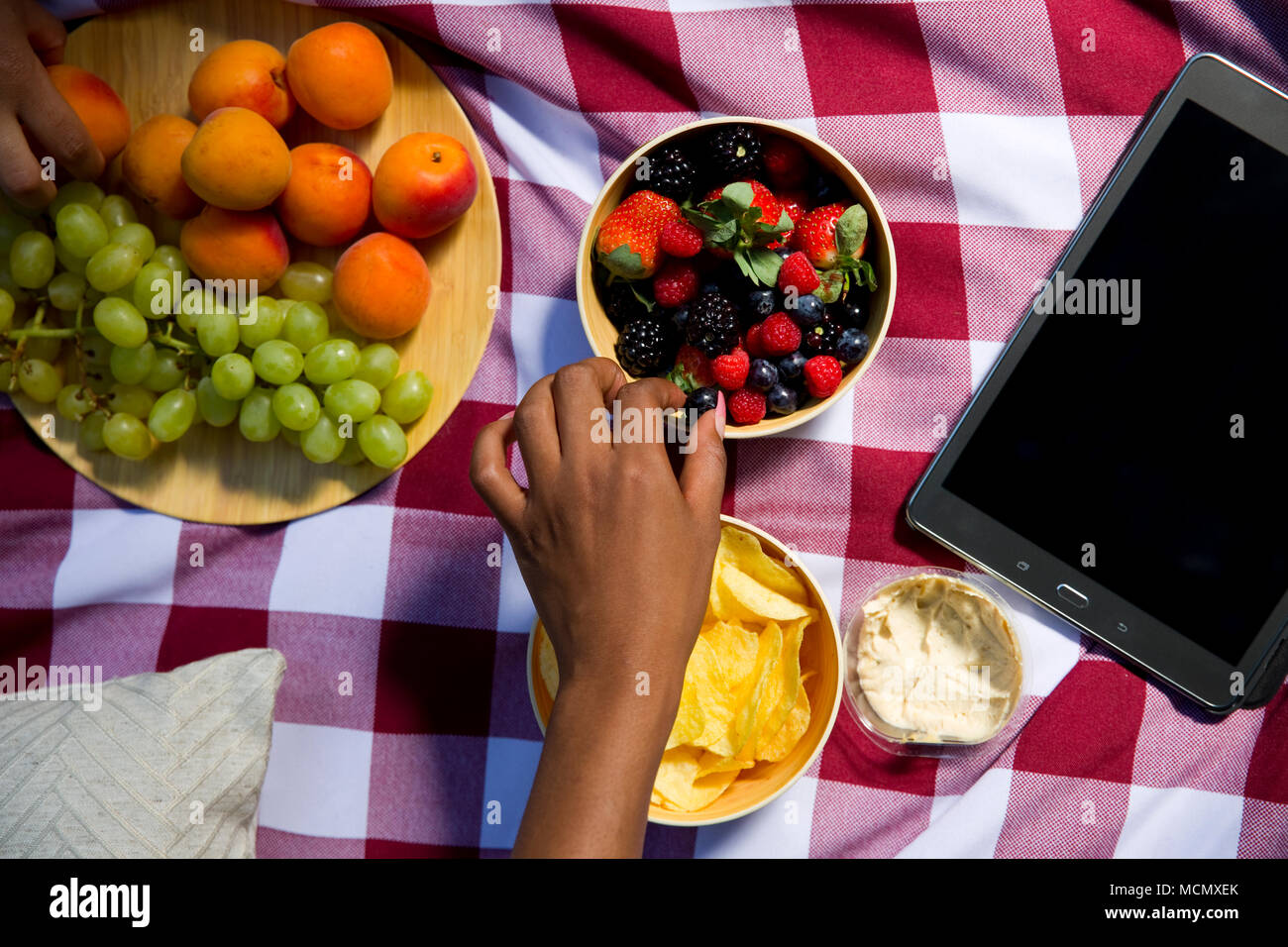 Frau essen Beeren an einem Picknick Stockfoto