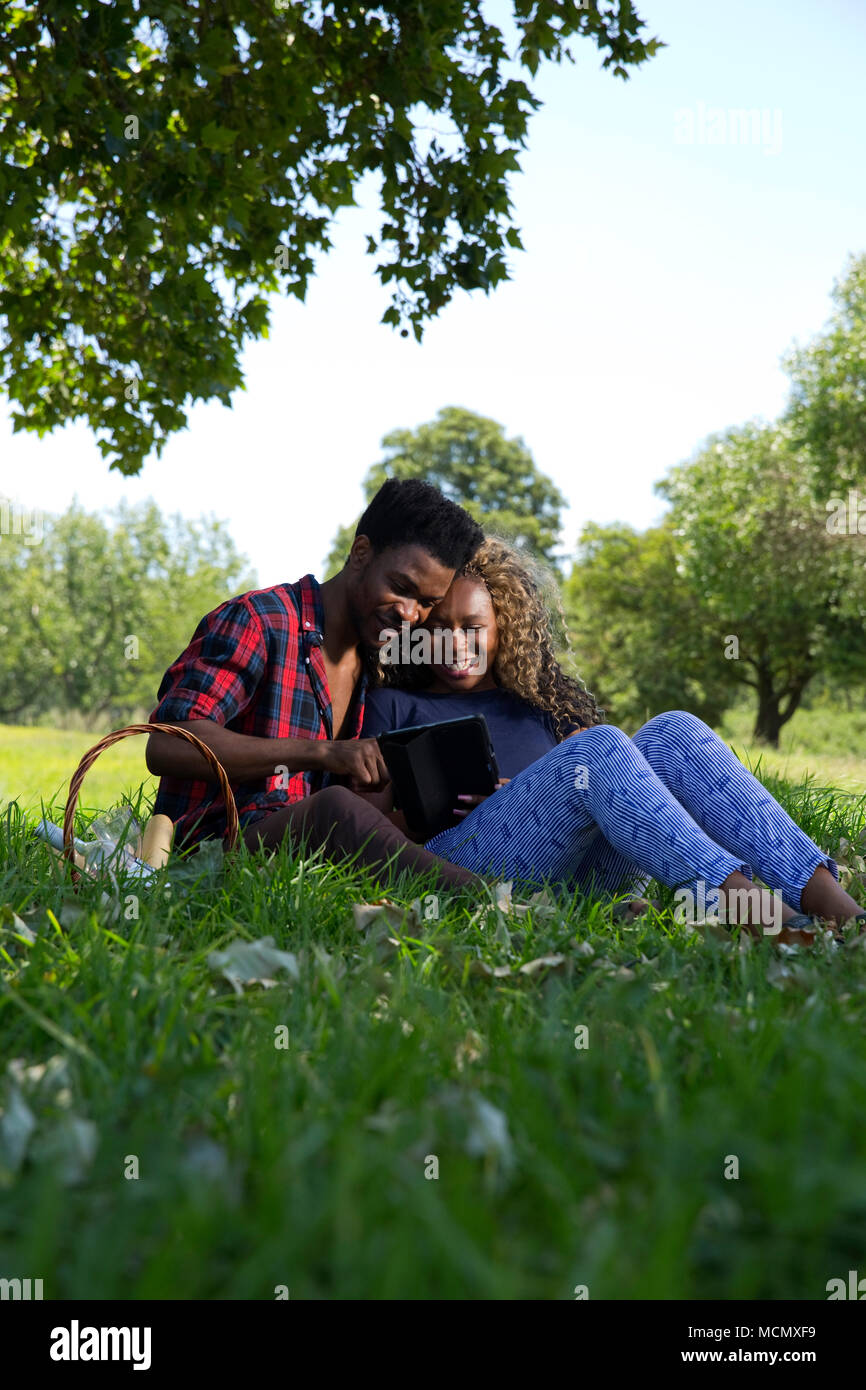 Paar an einer Tablette zu einem Picknick auf der Suche Stockfoto