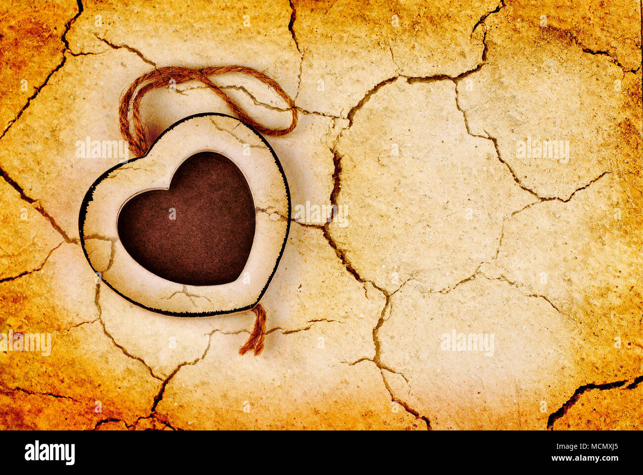 Holz Bilderrahmen in Herzform auf trockene rissige grunge Erde Hintergrund Stockfoto