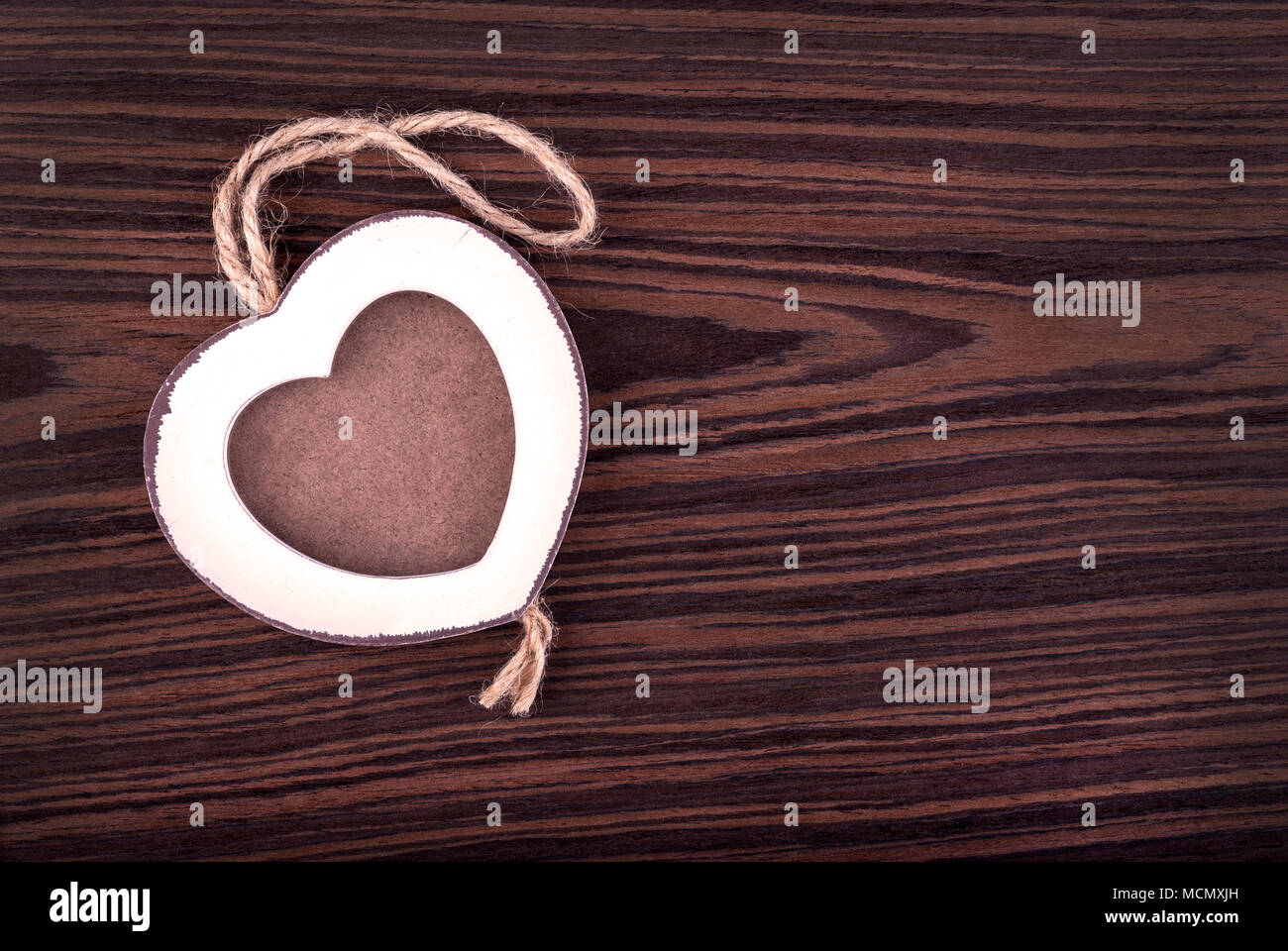 Holz Bilderrahmen in Herzform auf wengeholz Hintergrund. Stockfoto