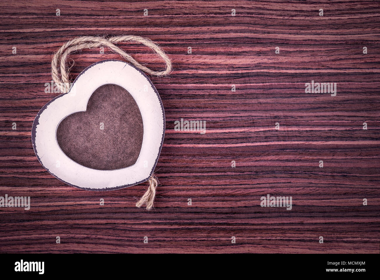 Holz Bilderrahmen in Herzform auf Palisander Holz Hintergrund. Stockfoto