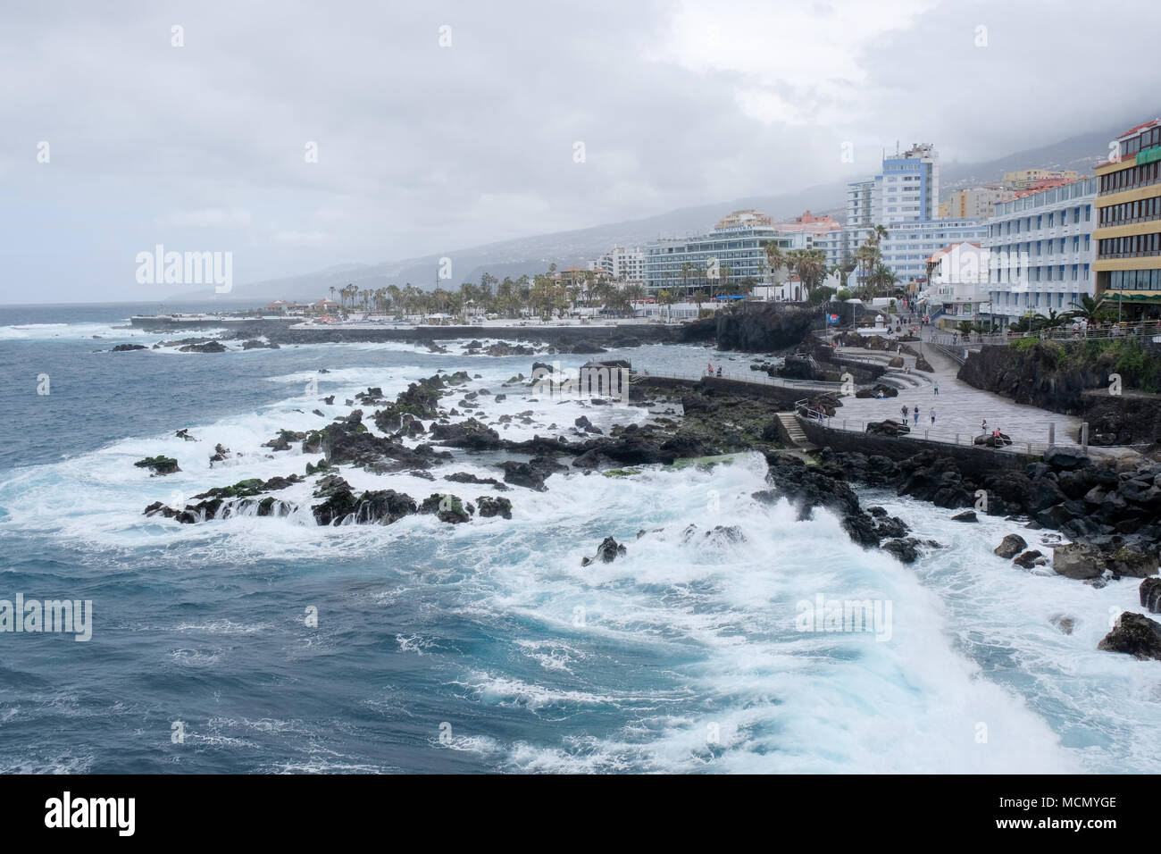 Puerto de la Cruz, Teneriffa, Kanarische Inseln; raue See auf der gepflegten Strandpromenade, als der Wind von einem herannahenden Sturm holt. Stockfoto