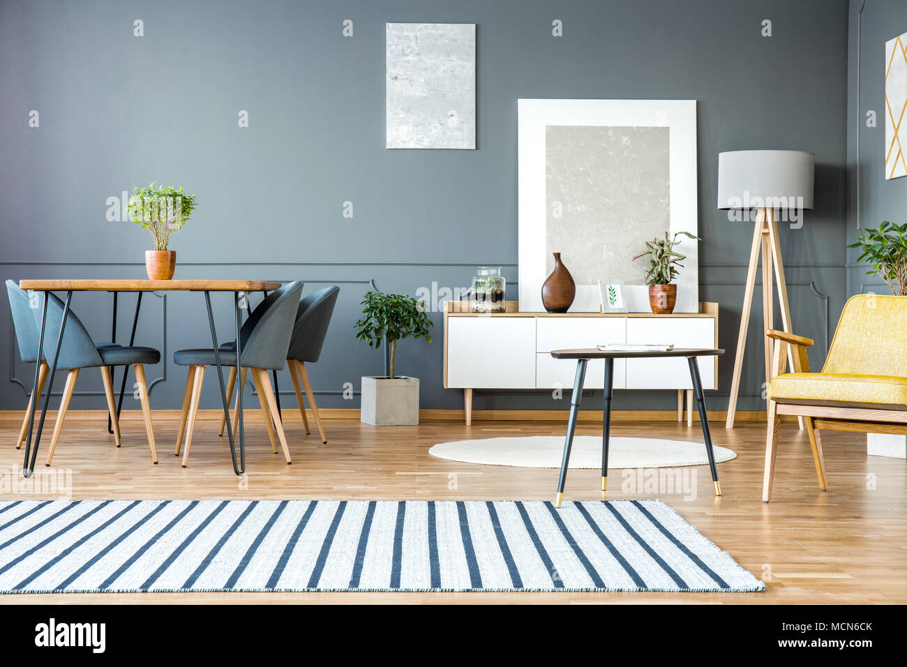 Gestreiften Teppich In Grau Wohnung Interieur Mit Stuhle Am Esstisch Und Gemalden An Der Wand Stockfotografie Alamy