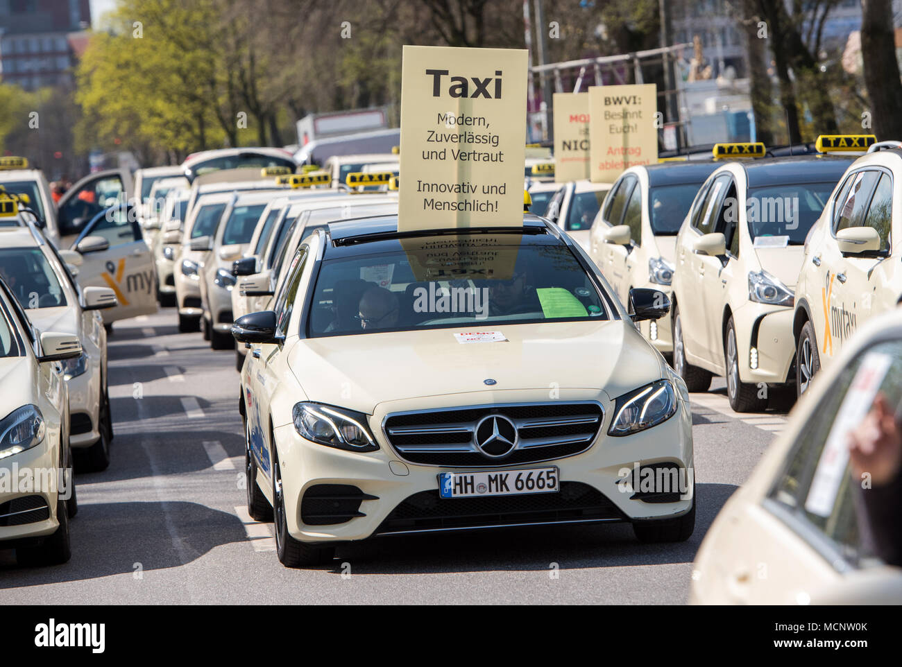 17 April 2018, Hamburg, Deutschland: ein Schild mit der Aufschrift "Taxi. Modern, zuverlässig und vertrauenswürdig. Innovation und Humankapital" wird von einem Taxi während ein Protest der Taxifahrer statt. Rund 300 Taxifahrer gegen die geplante Test Drive von gemeinsam genutzten Elektro Taxis der VW-Tochter "Oia" demonstriert. Volkswagen plant für den Anstieg an die Spitze der führenden Anbieter von Mobilitätsdienstleistungen. Die Tester sind in der Lage, Buchen und Bezahlen für einen Shuttleservice mit einem Smartphone App. Foto: Daniel Bockwoldt/dpa Stockfoto