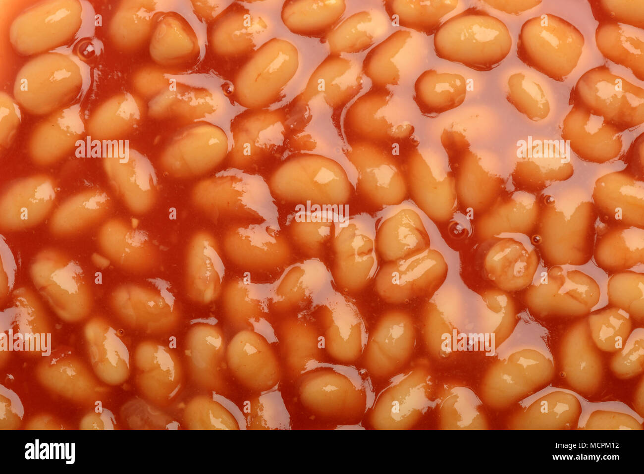 Gekochte Bohnen Hintergrund Textur mit Tomatensauce. Stockfoto