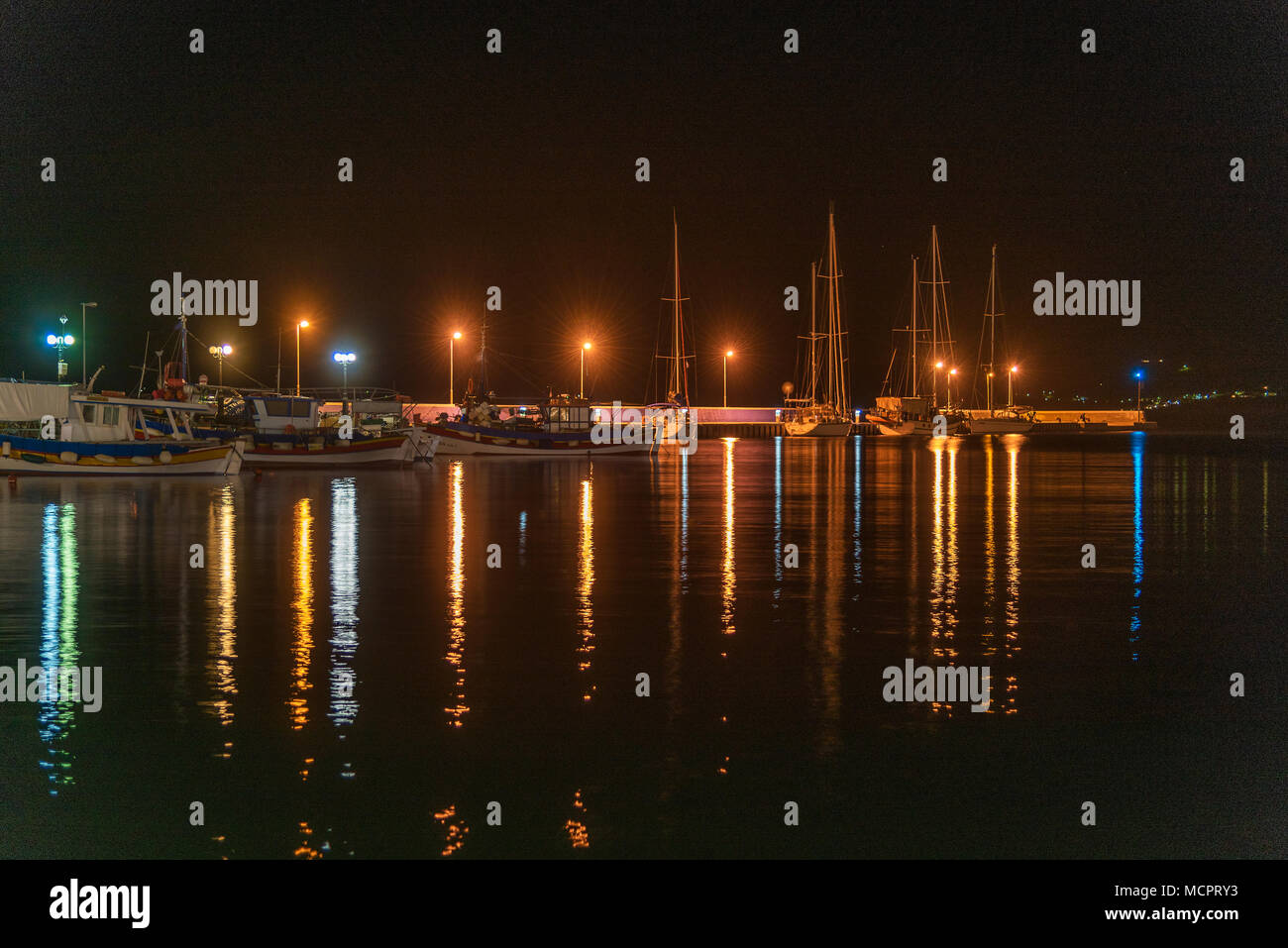 Der Hafen von Sitia auf Kreta bei Nacht mit Spiegelungen der Leuchten im Wasser Stockfoto