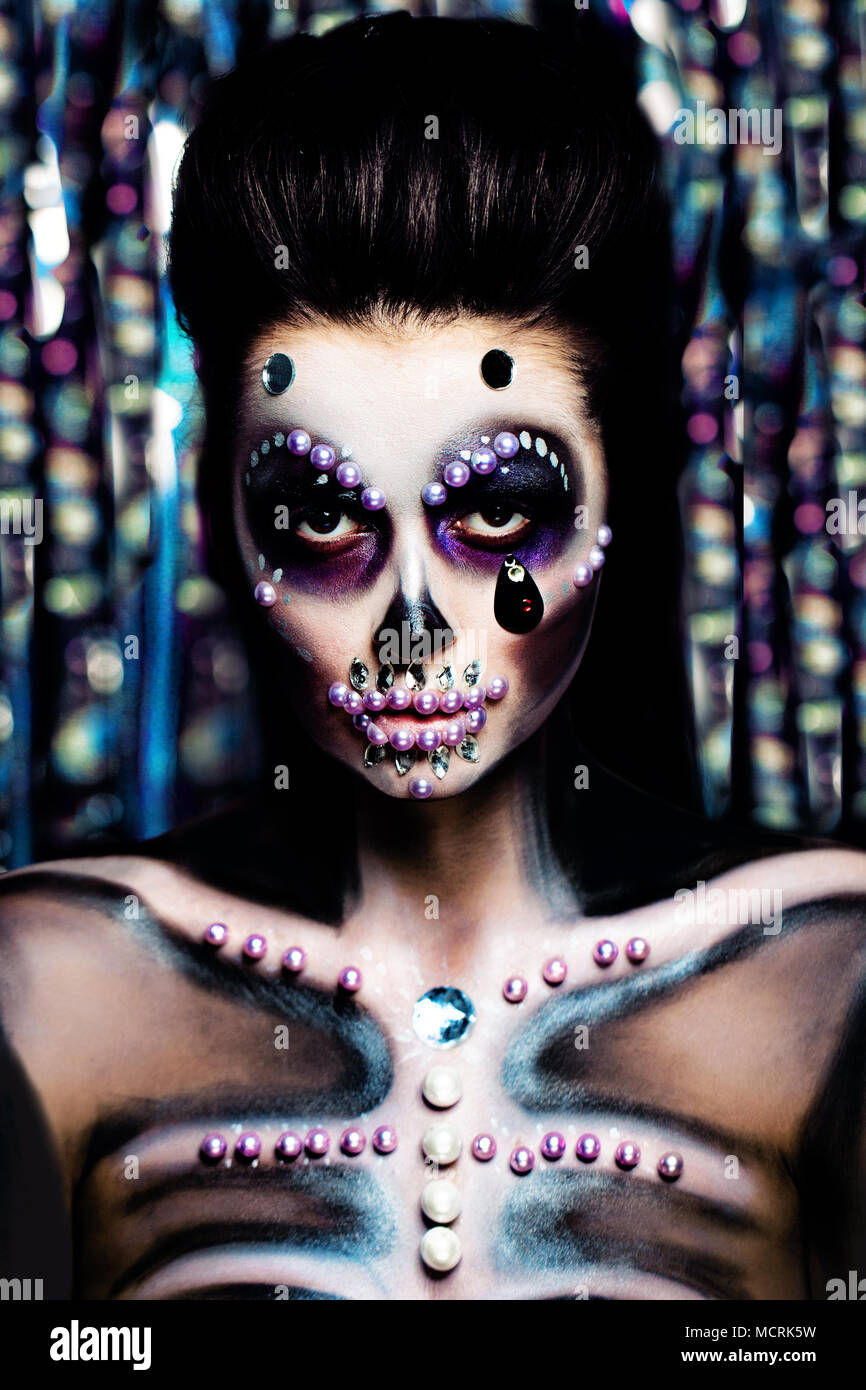 Halloween Frau mit Halloween Make-up auf bunten Bokeh Hintergrund. Glamour Skelett Bilden Stockfoto