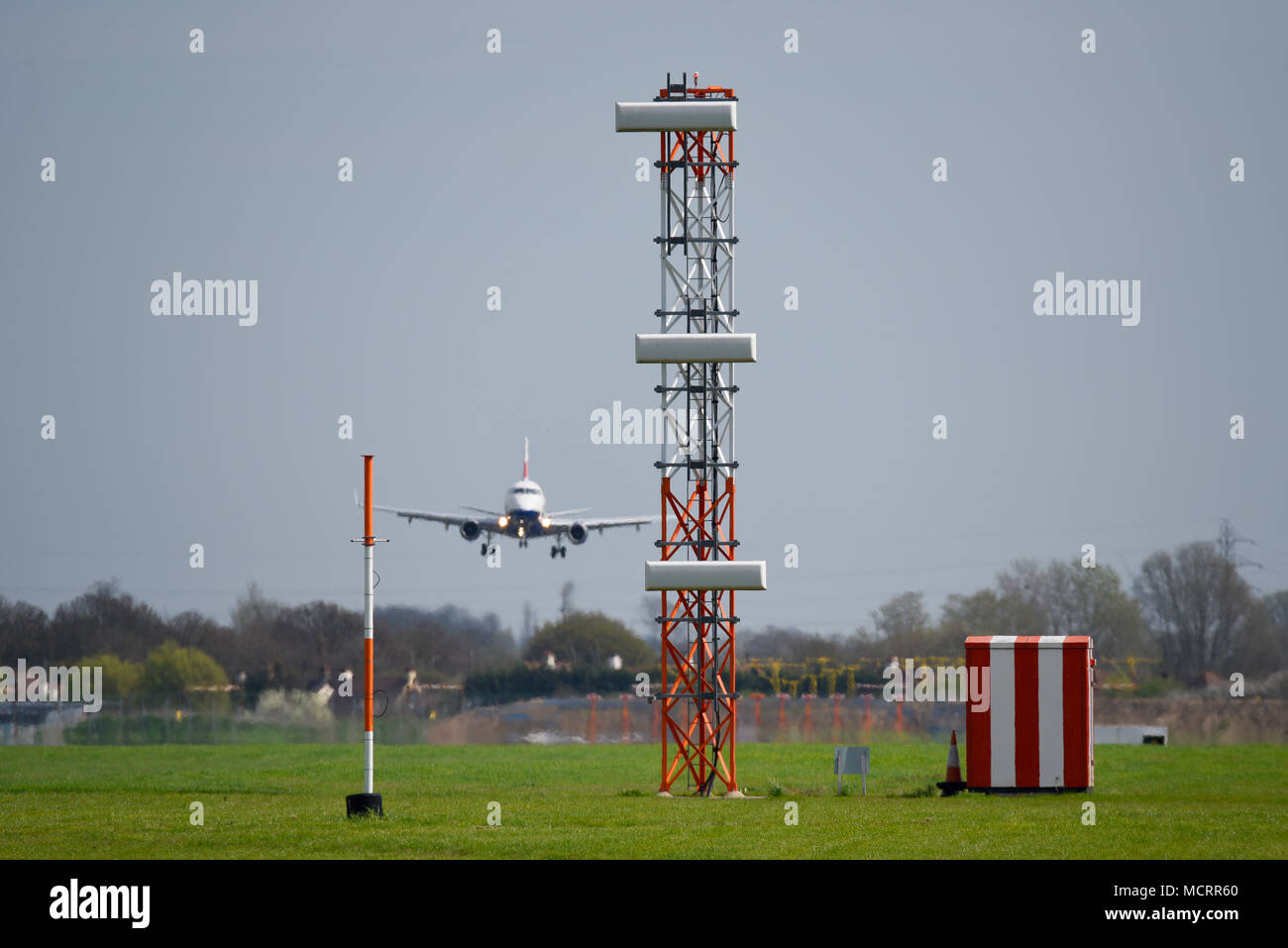 ILS Gleitwinkel Turm landing System in London Luton Flughafen. Infrastruktur. Mit British Airways Embraer Jet plane Seite rutschen zu Land Stockfoto