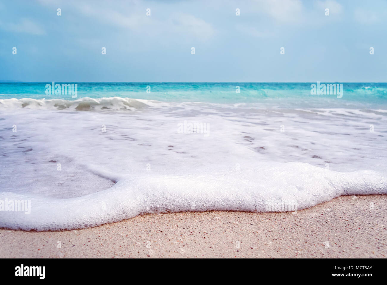 White Wave Schaum am Strand von Barcelona. White sea Foam close-up am Sandstrand von einer exotischen Insel. Schöne Landschaft Stockfoto